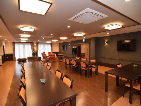 ブラウン系の内装に、長いテーブルと椅子が並べられた食堂