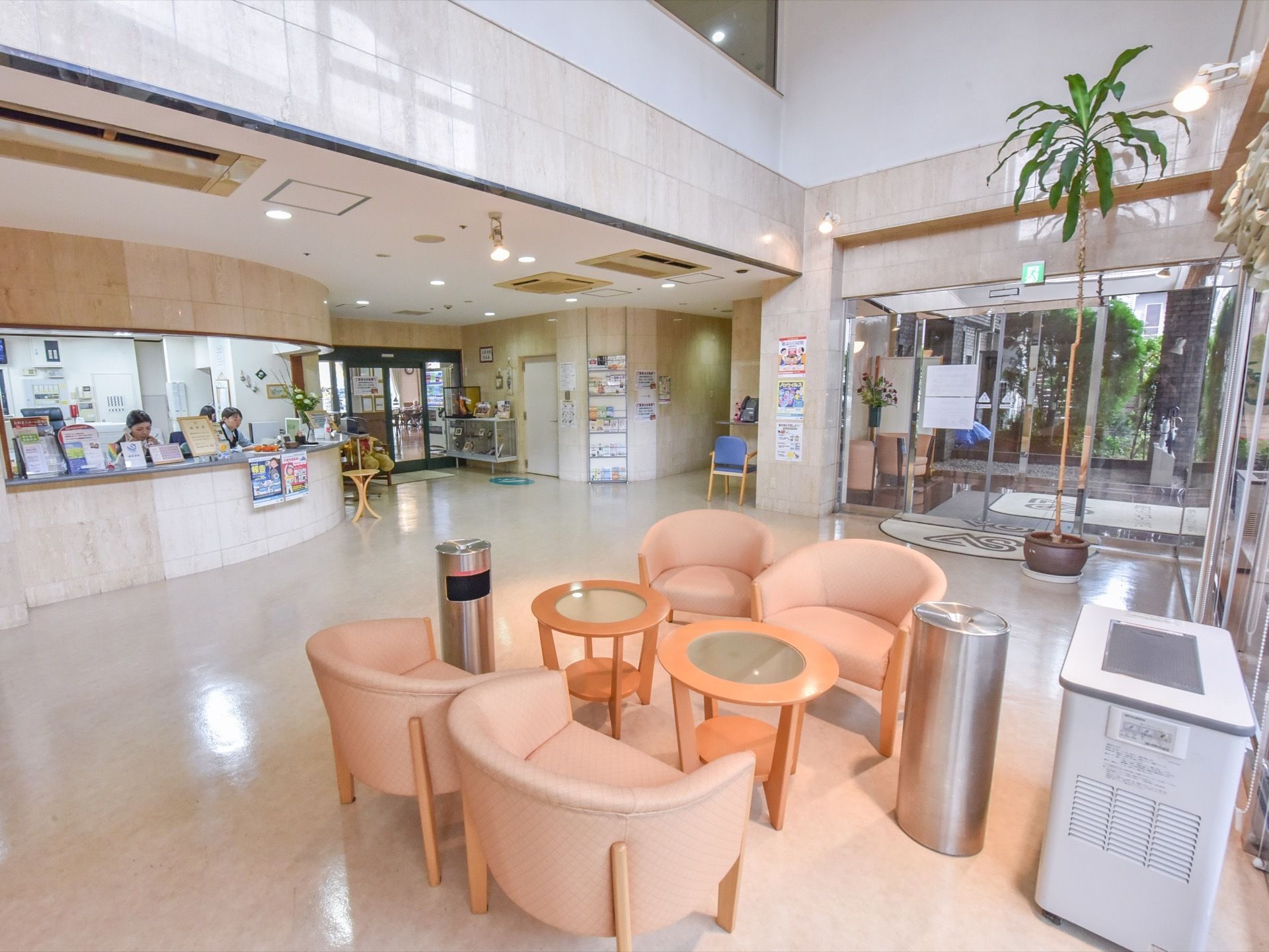 施設の入口を入ってすぐの部分に受付があり、女性スタッフが数人働いている。壁際にはテーブルとイスがある。