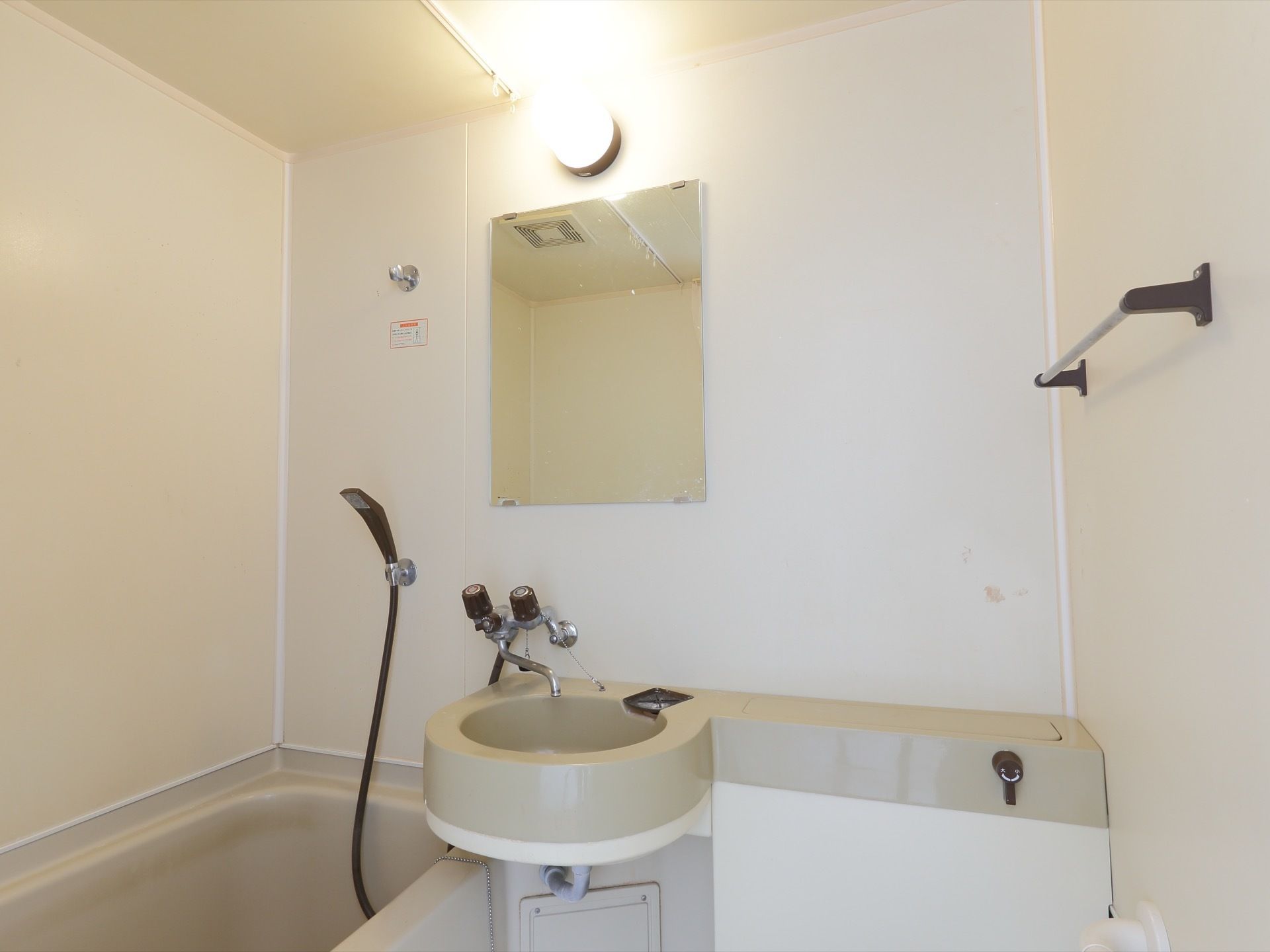 浴室内に、洗面台、浴槽、トイレが集約された、コンパクトな空間。鏡とタオル掛けもついていて、使いやすくなっている。