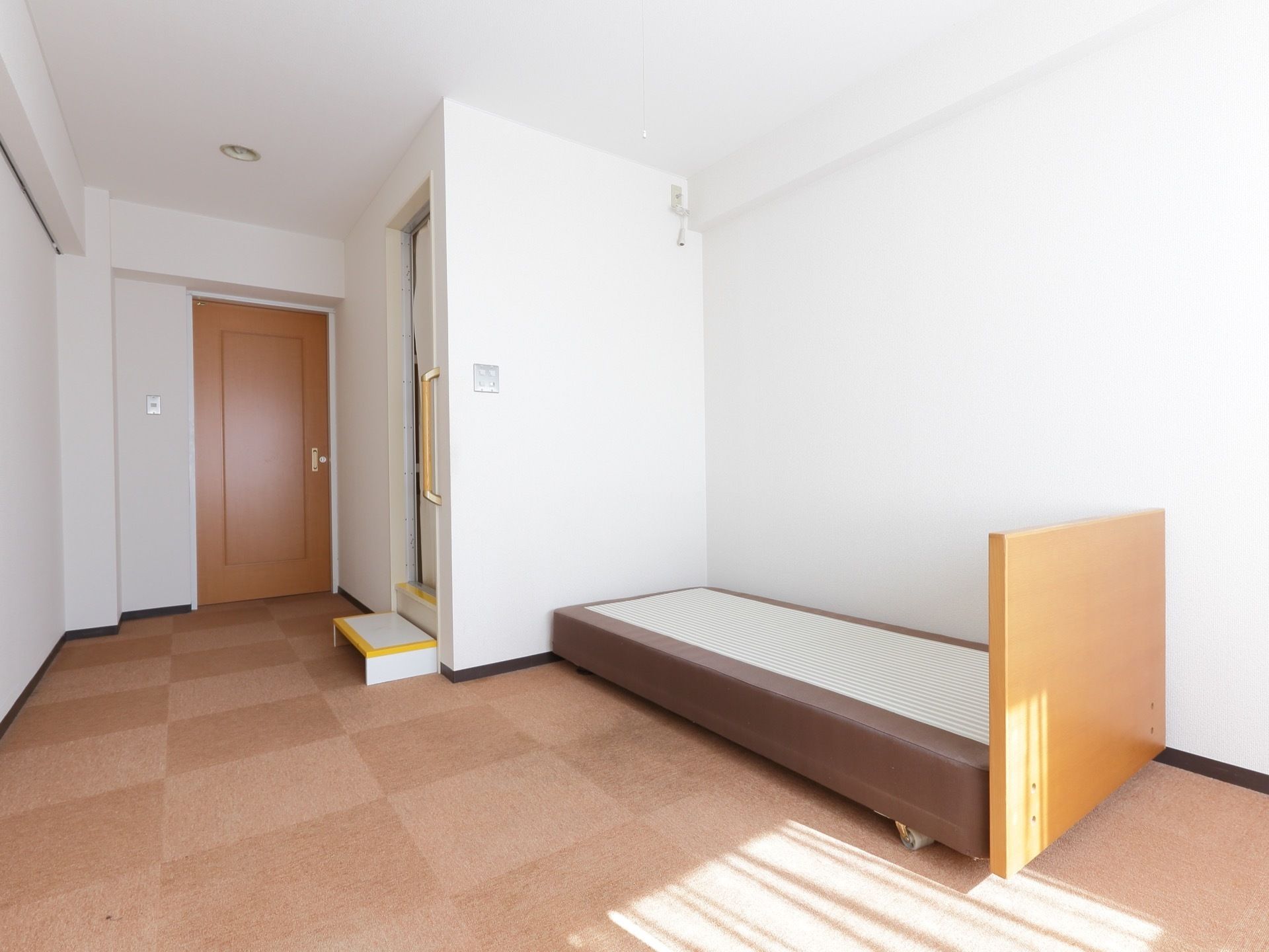 室内には、ユニットバスとベッドがある。ユニットバスの入口は、高くなっているため、台と手すりがつけられ、安全性が考慮されている。