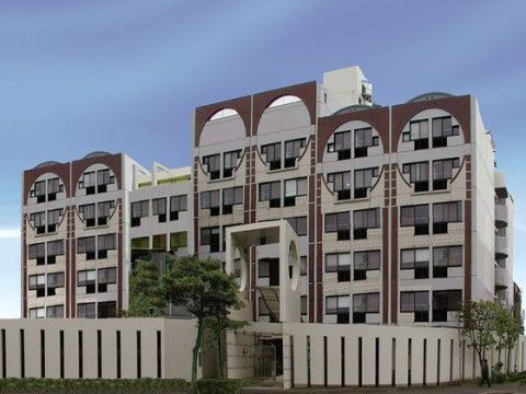白地にブラウンの縦のラインやアーチが配されたデザインの建物