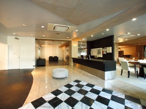 右側に黒いカウンターと仕切りのある、丸いスツールの置かれたホール