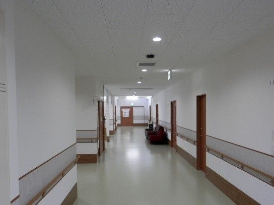 壁に手すりが設置され椅子が配置された廊下