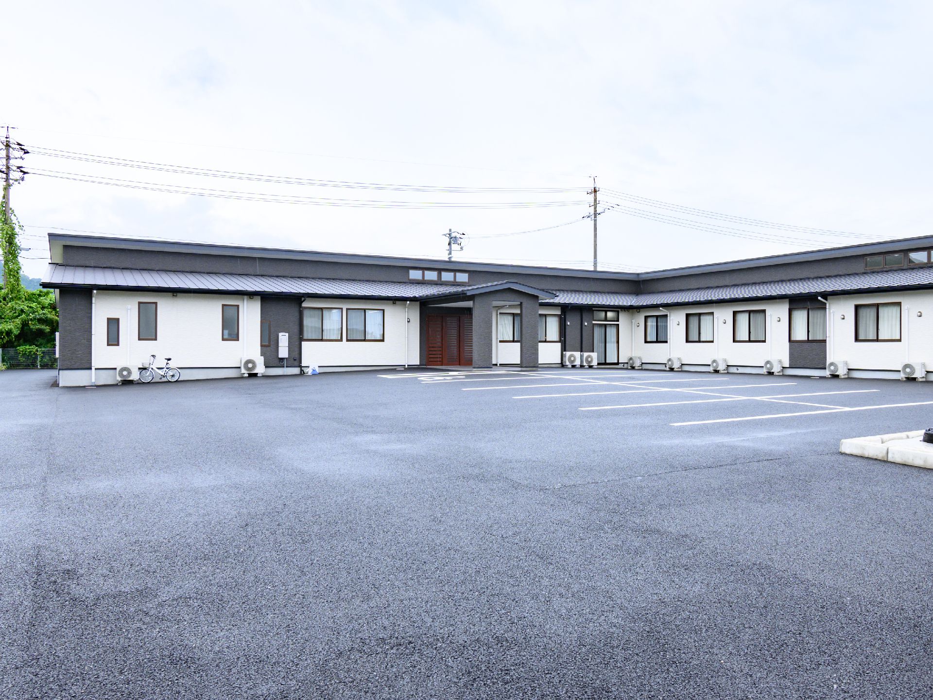 落ち着いた色合いで、駐車場も設置されている外観