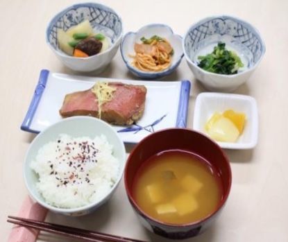 焼き魚に漬物、3つの小鉢と味噌汁が添えられた食事例