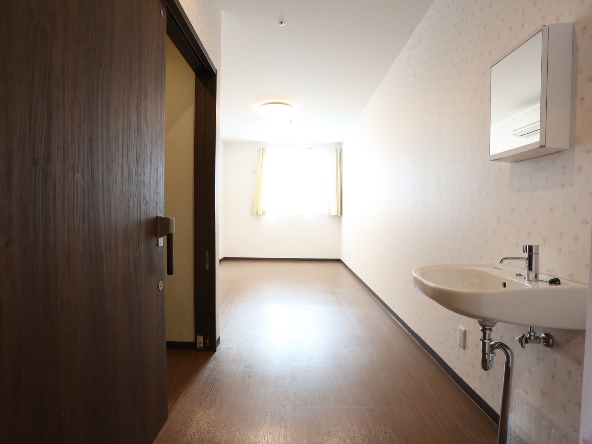 奥にある窓から日が入り、部屋全体を明るく照らしている。壁紙は可憐な小花柄で柔らかい雰囲気になっている。