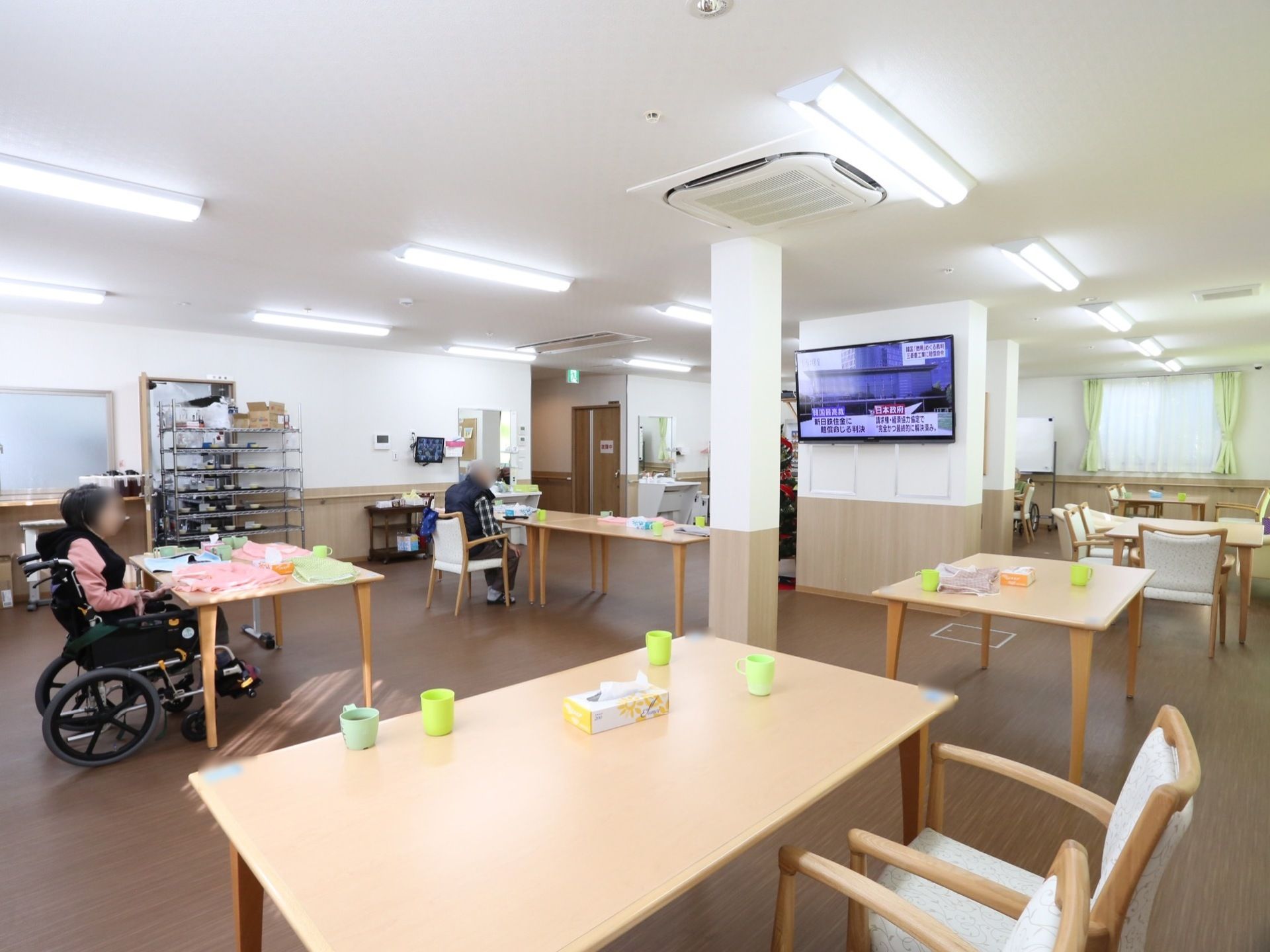 広々とした室内にテーブルが広く間隔を空けて配置されている。それぞれテレビの見やすい角度に調節されて椅子が置かれている。