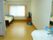 洗面台や介護ベッド、エアコンが完備された居室である。トイレやカーテンも備わっており、壁際にテレビが設置されている。