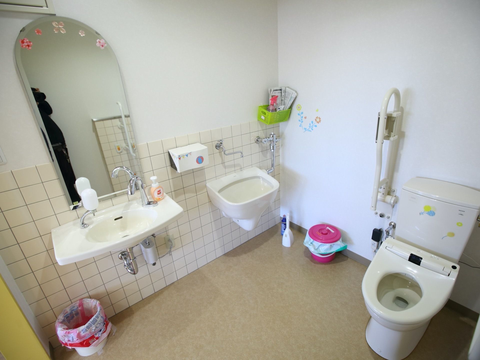 トイレと洗面台がある。洗面台の前には大きな鏡が取り付けられている。また、便器の横には手すりが設置されている。