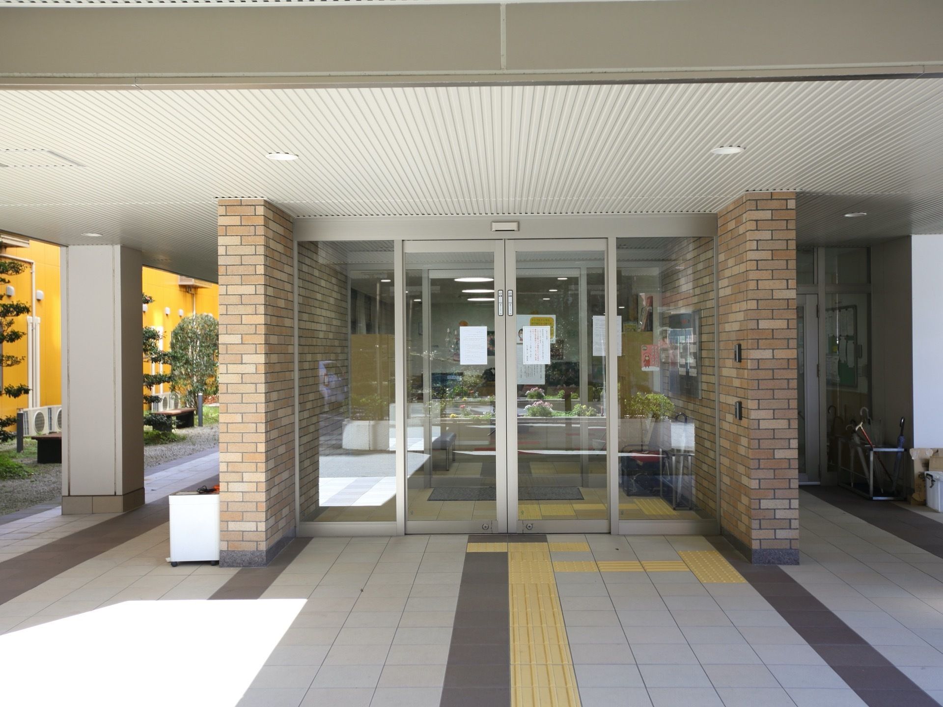 レンガ調のおしゃれな玄関はに横幅の広い自動ドアが取り付けられている。また、ドアの前までは黄色の点字ブロックが敷かれている。