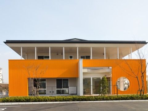 道路沿いにある近代的な外観の建物。丸くくり抜かれた壁やアシンメトリーな造りは、まるでデザイナーズ住宅のようである。