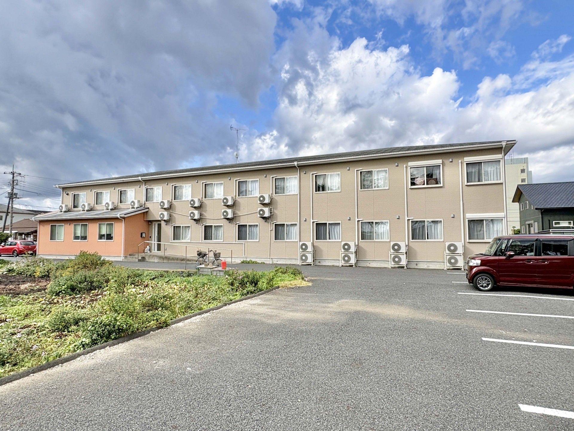 薬を飲む高齢女性と水を差し出す女性スタッフ