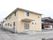 閑静な住宅街の中に建つグループホームで、周辺に高い建物がない。外壁に沿ってエアコンの室外機が並べて置かれている。