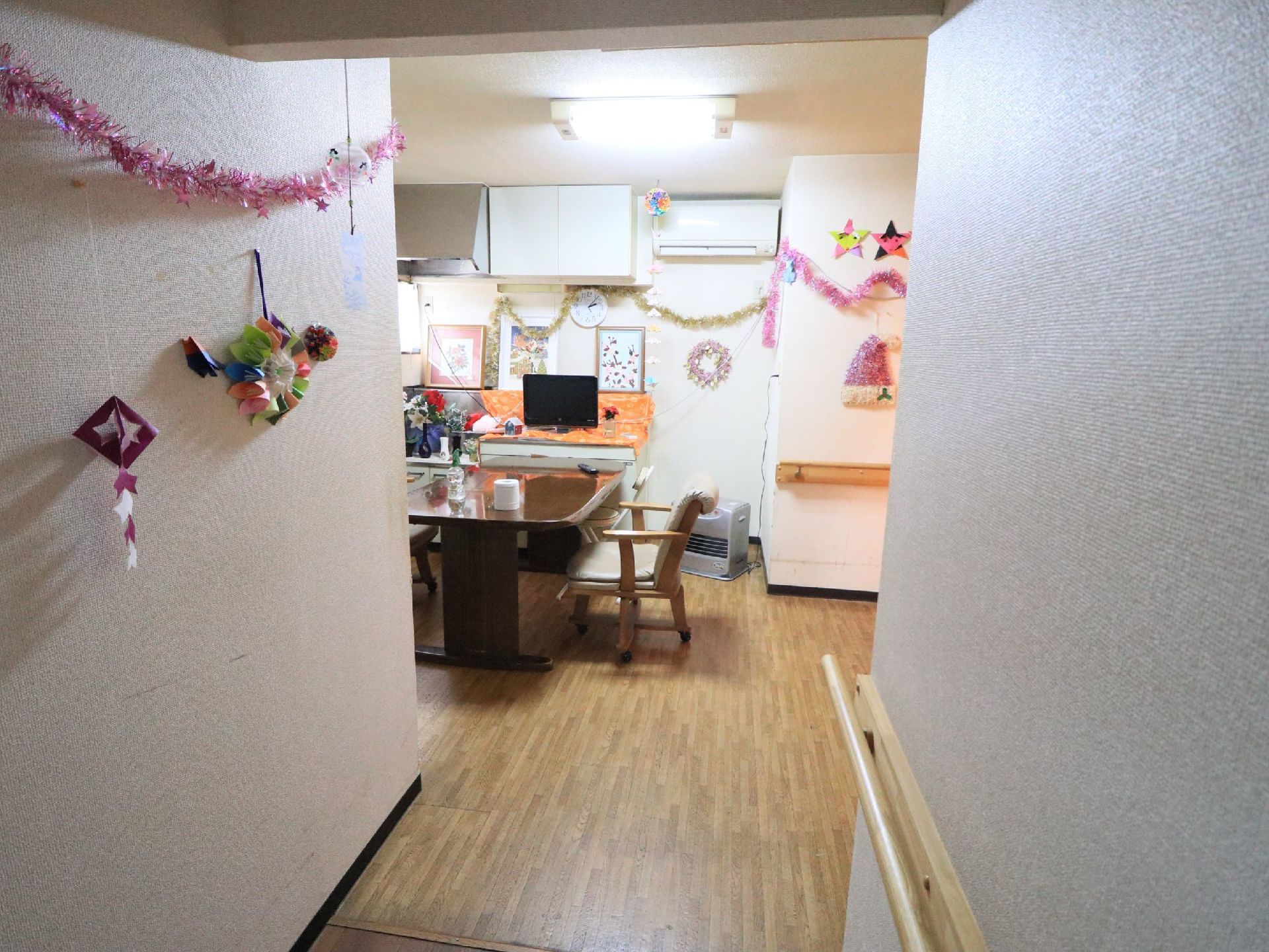 入り口よりラウンジを覗いた様子である。テーブルと椅子がセットされている。入り口と部屋の壁には手作りの飾りつけがされている。