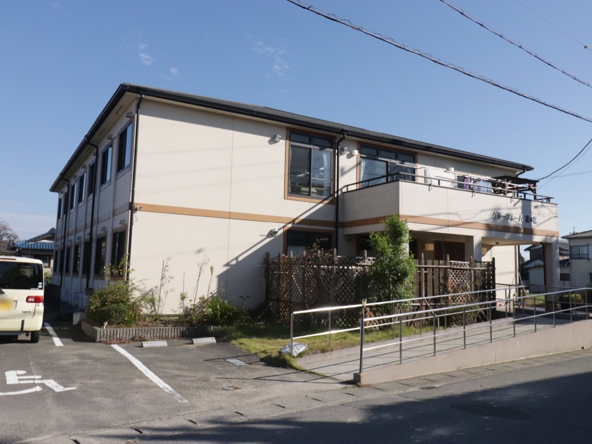 施設では建物の左側にアスファルト舗装の駐輪場を設けている。入り口に近い場所には車椅子マークを記している。