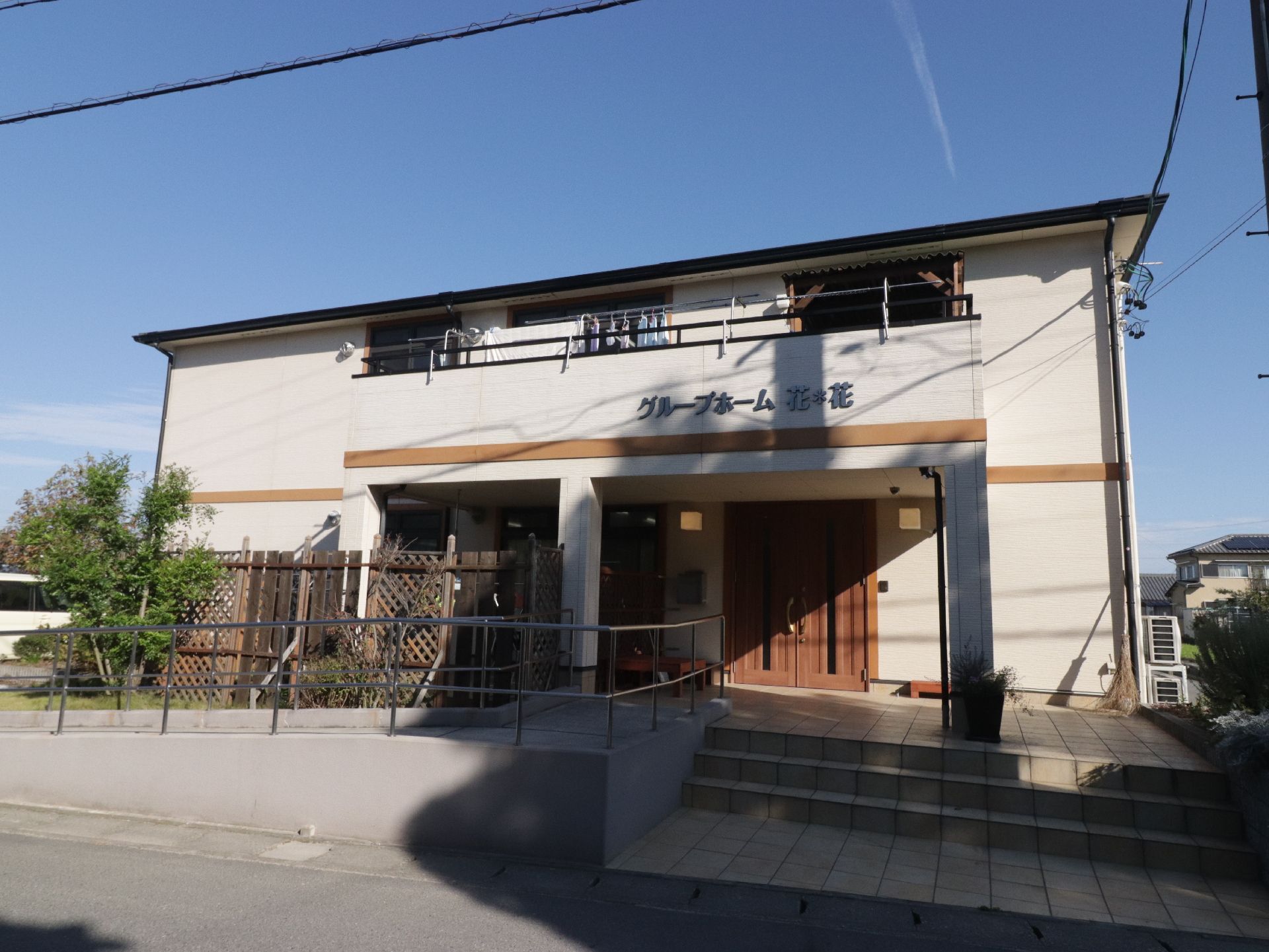 1階と2階の間に茶色のラインの入った白い2階建ての建物