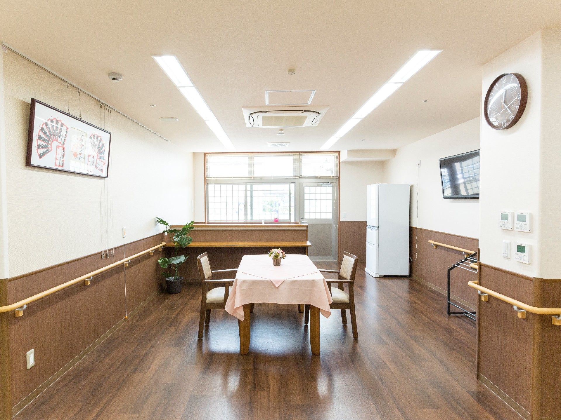 白と板張りの切り替えになった壁面とフローリング、真ん中にクロスのかかった二人用のテーブル