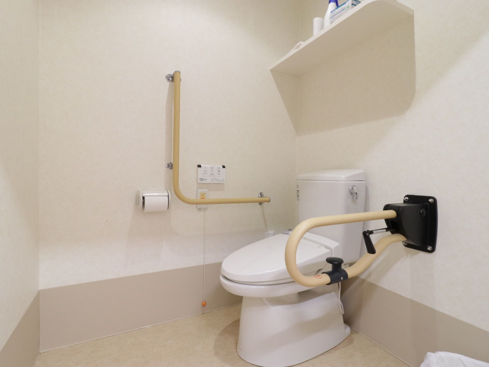 共通トイレは誰でも使用しやすいように広く、バリアフリー対応となっている。洗浄や緊急用ボタンが壁に設置された安心の設計である。