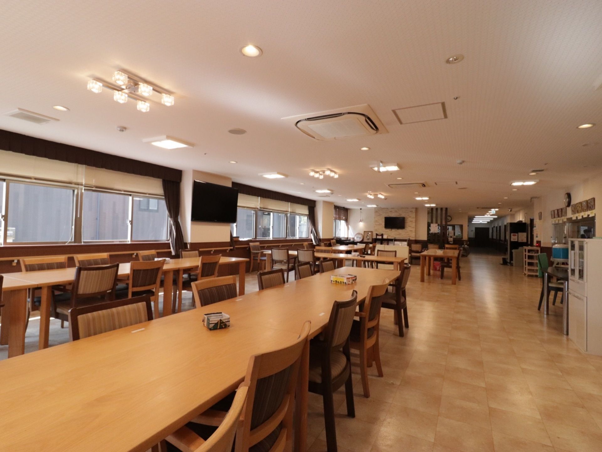 入居者様が集まり、賑やかな空間で栄養バランスの取れた食事を食べることができる。高級感ある造りがレストランのようである。