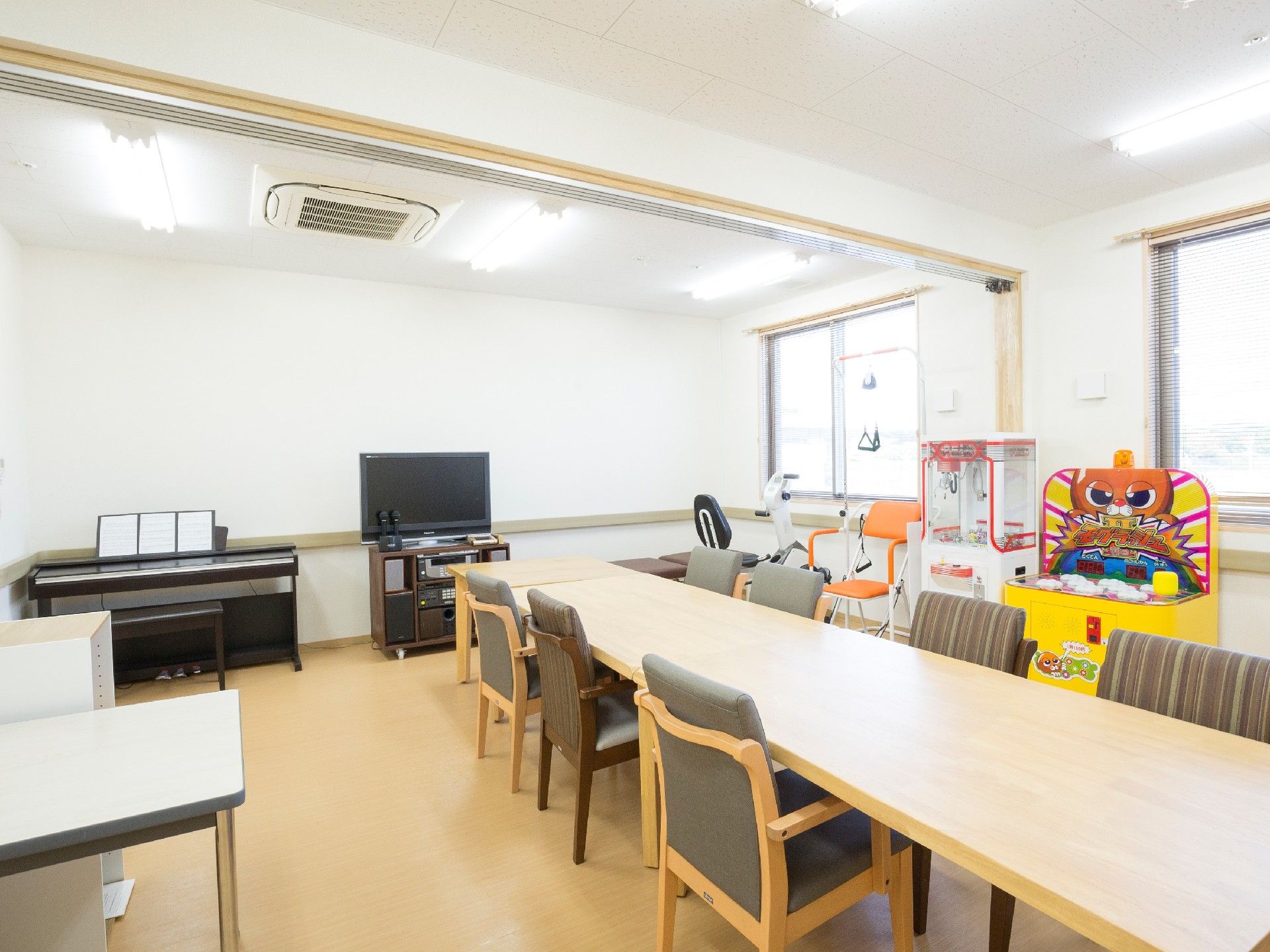右壁面にモグラをたたくゲーム、左壁面にテレビと電子ピアノが置かれた共用スペース
