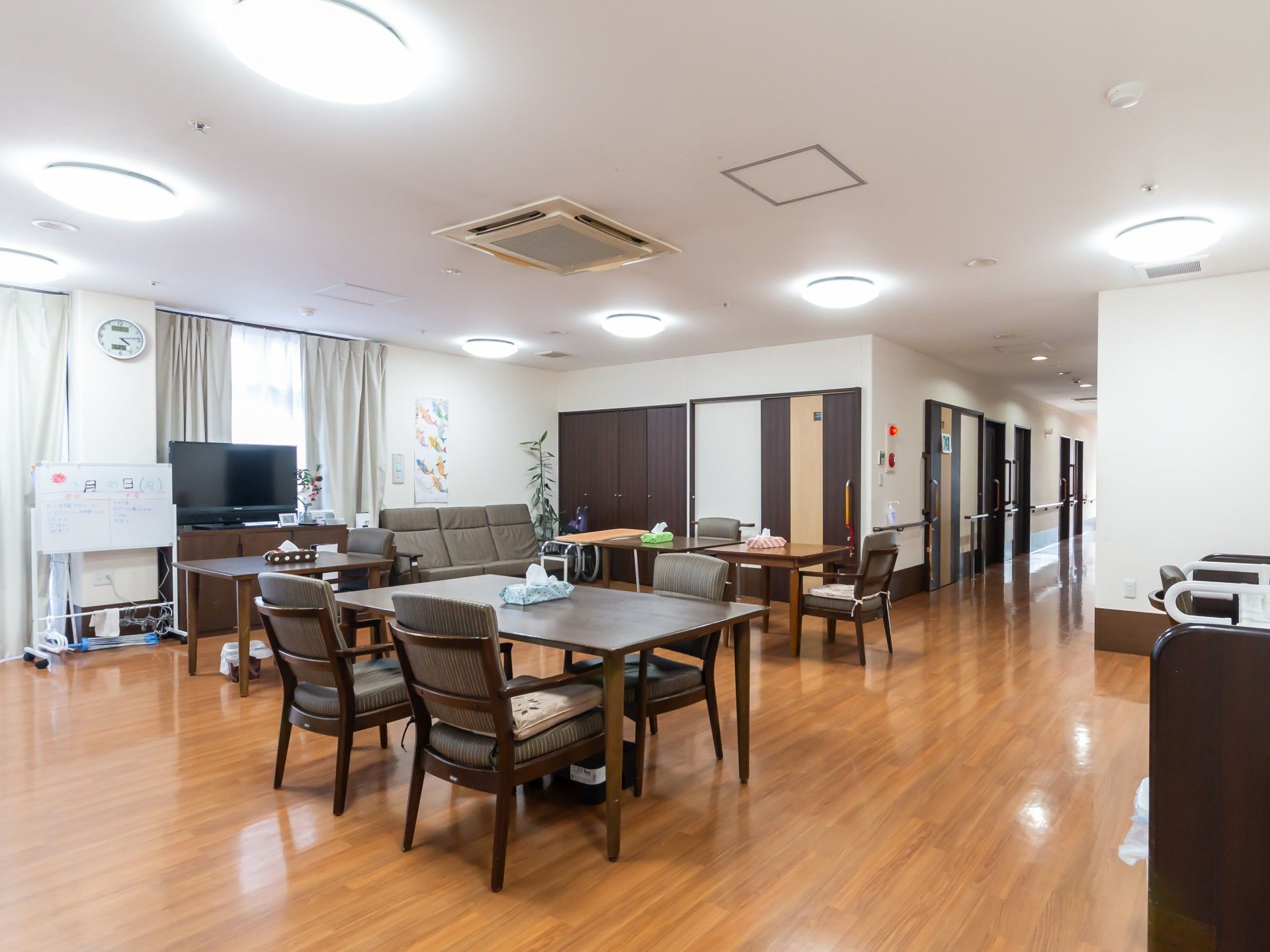 肘掛けや背もたれを設けた、白を基調とした広い個室トイレ
