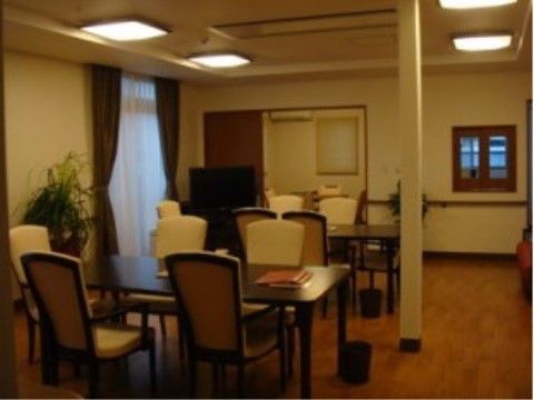 壁には連続した手すりが付けられている。窓の横にはグリーンが配置され、落ち着いた雰囲気になっている。部屋の隅には大型テレビが置かれている。