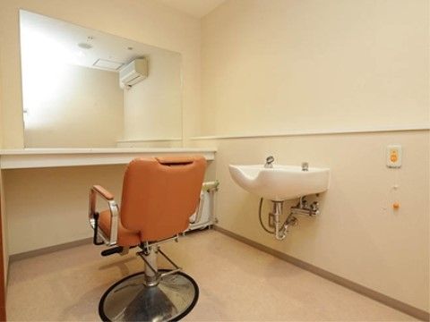 大きな鏡、洗面台が供えられた理美容室では、専門スタッフが対応する。入居者様の美意識や清潔感を保つために用意されている。