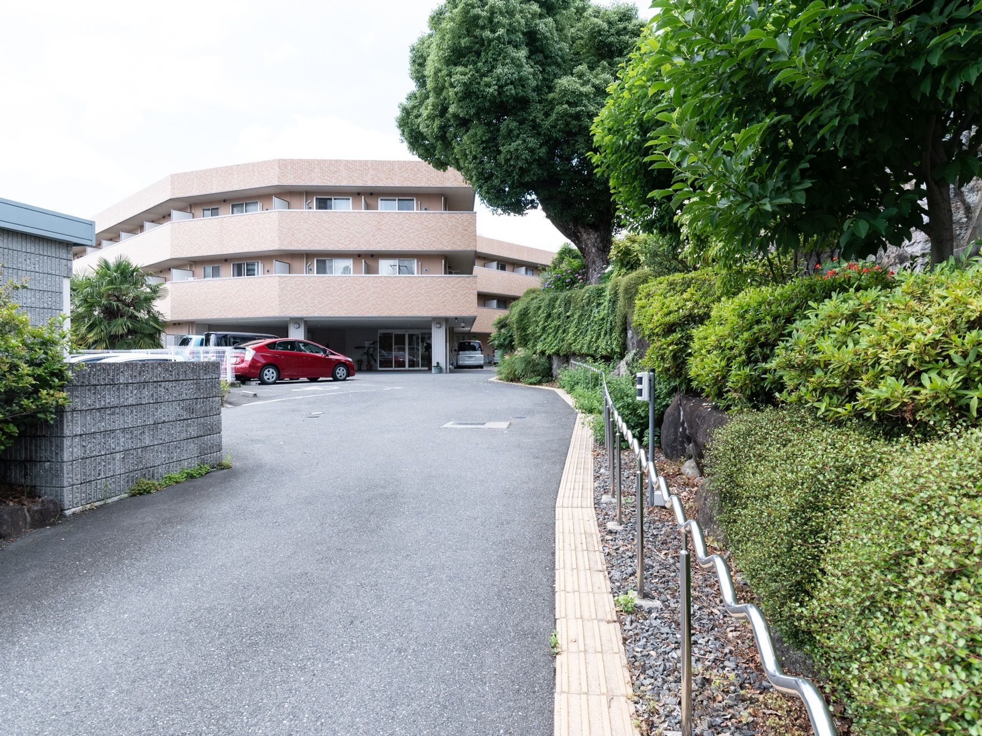 緩やかな坂道の上に本施設の建物が立っている。淡いブラウン系の３階建ての建物でモダンなデザインとなっている。