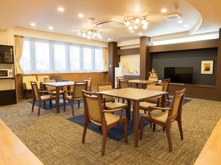奥の壁にテレビが配置された、シャンデリアのある豪華絢爛な談話室