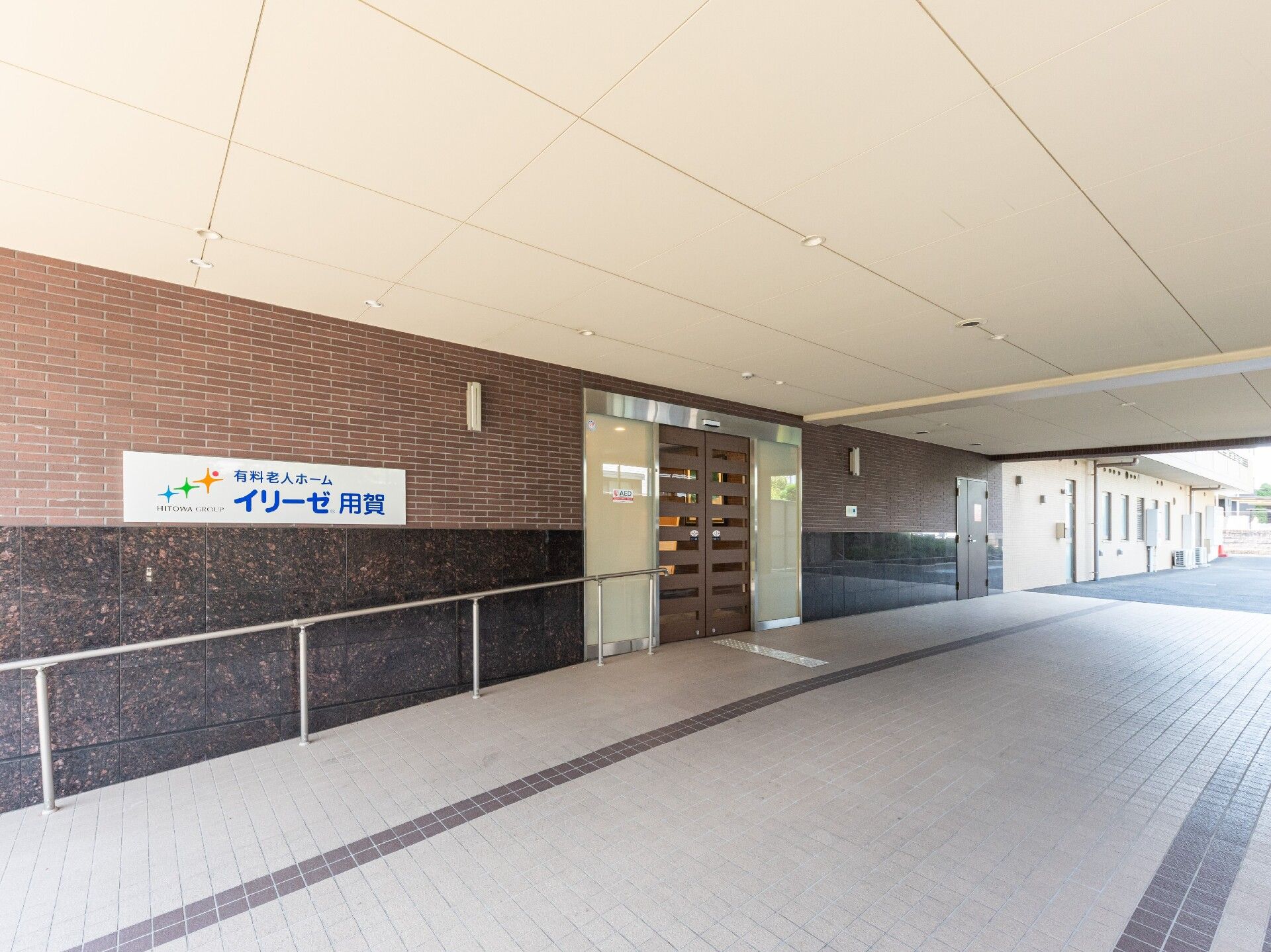 手すりが設置されたエントランス周辺には段差はなく、ホーム名が書かれたプレートが貼られている。