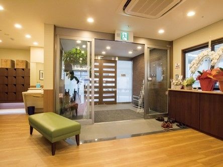玄関はバリアフリーになっており自動ドアが2重になっている。壁には手すりがついておりアートもかけられている。