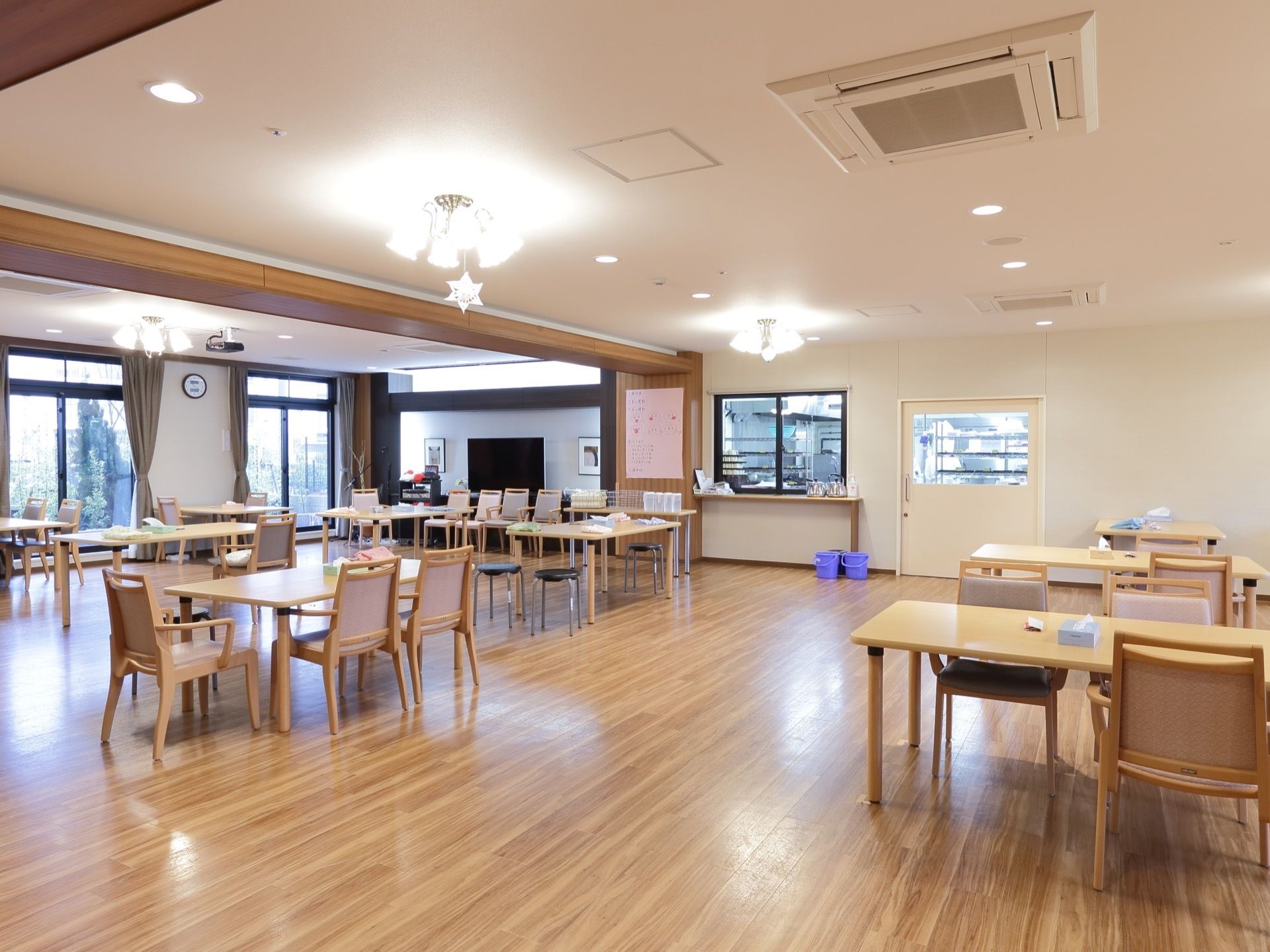 食堂は広く落ち着いた雰囲気で、大きなスクリーンが設置されている。椅子にはひじ掛けがあり、安全に食事を楽しむことができる。