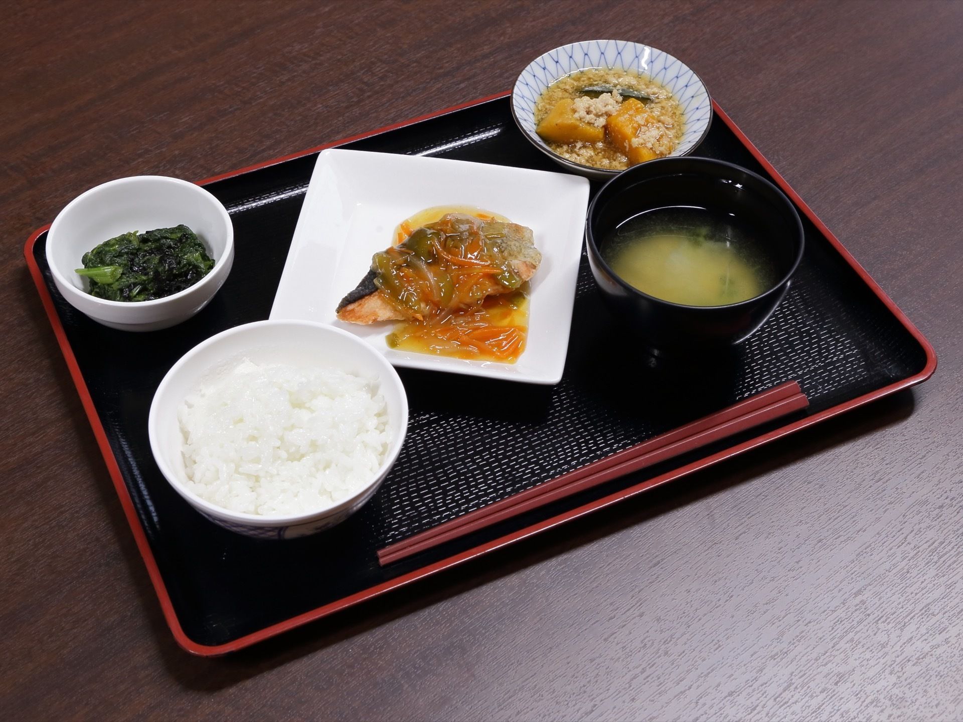 シックな黒のトレーで食事を提供している。お魚の主菜と野菜が使われた副菜2品という栄養のバランスも良い献立になっている。