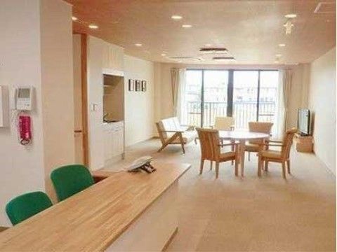スタッフステーションには、入居者様が自由に使うことのできるテーブルやソファ、大型テレビが置かれている。ミニキッチンも設置されている。