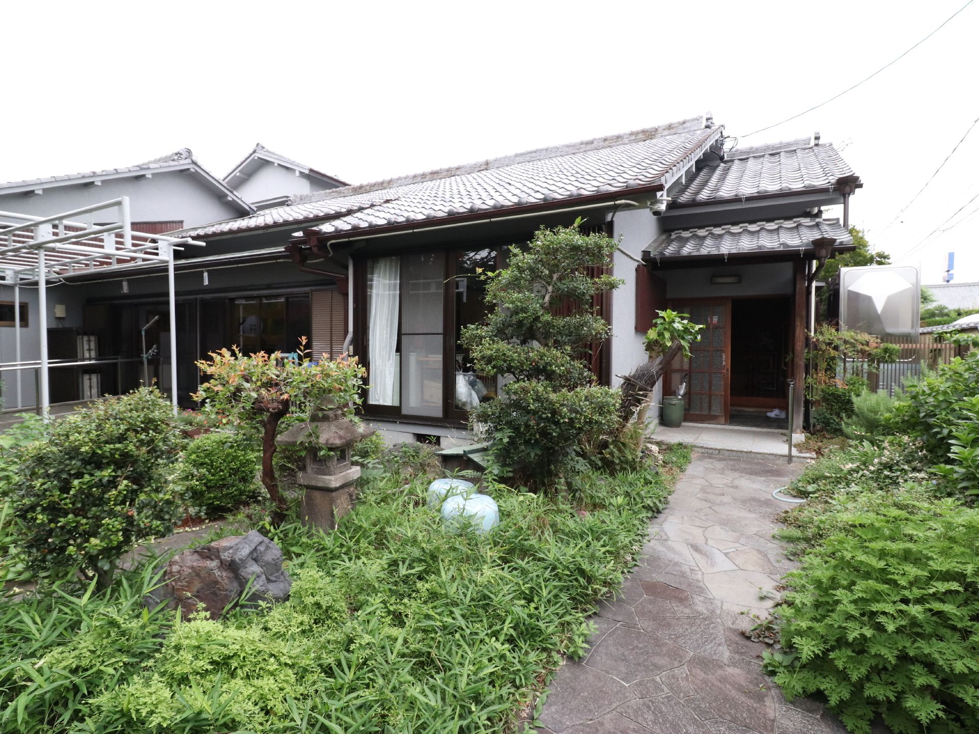 グループホームの建物は、日本家屋の平屋建てになっている。玄関先には灯籠があり、木々が植えられている。