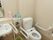 トイレの床にはごみ箱が置いてある。手すりが手洗いとトイレの両方についているので、立ち居が困難な人も快適に利用できる。