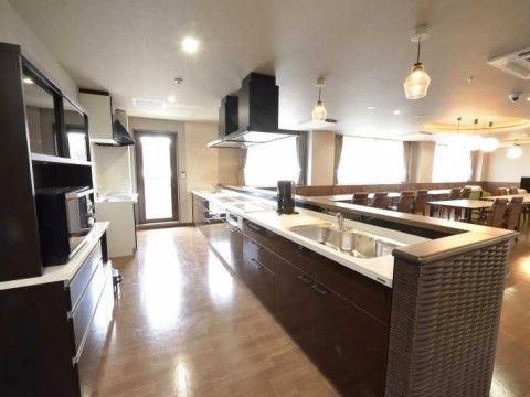 流しが広く、長いキッチンになっている。コーヒーメーカーが置かれており、奥にはIHタイプのコンロが設置されている。