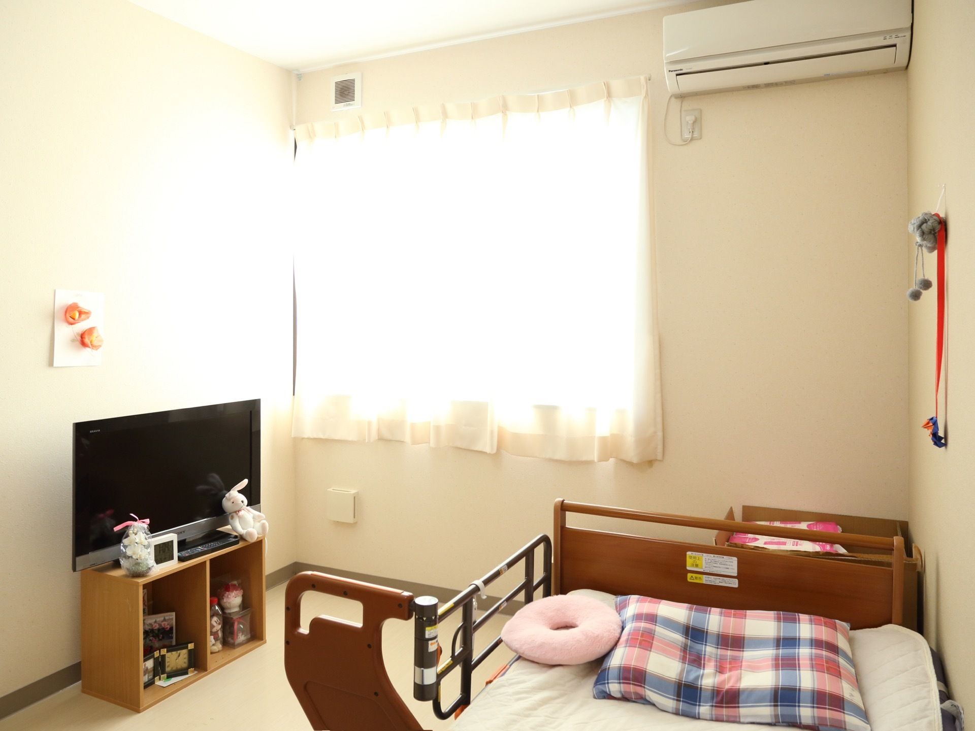 部屋にはエアコン、ベッド、テレビがある。ベッドは壁に付けられていて、片側に落下を防止する柵が取り付けられている。