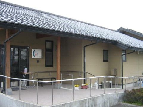 消毒液を載せたテーブルとベンチが扉付近に置かれた玄関