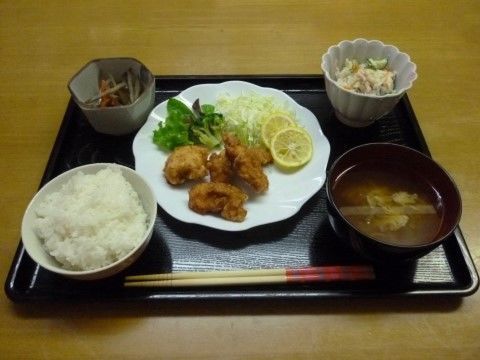 白米、レモンの添えられた唐揚げ、ポテトサラダ、きんぴらごぼう、味噌汁が配膳されたお盆