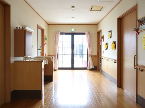 手すりがついた手洗いスペースを設けた、通路の広い廊下