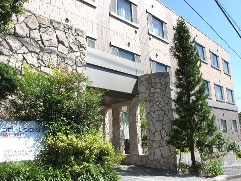 石造りの太い柱と針葉樹が外国を思わせるような施設のエントランス