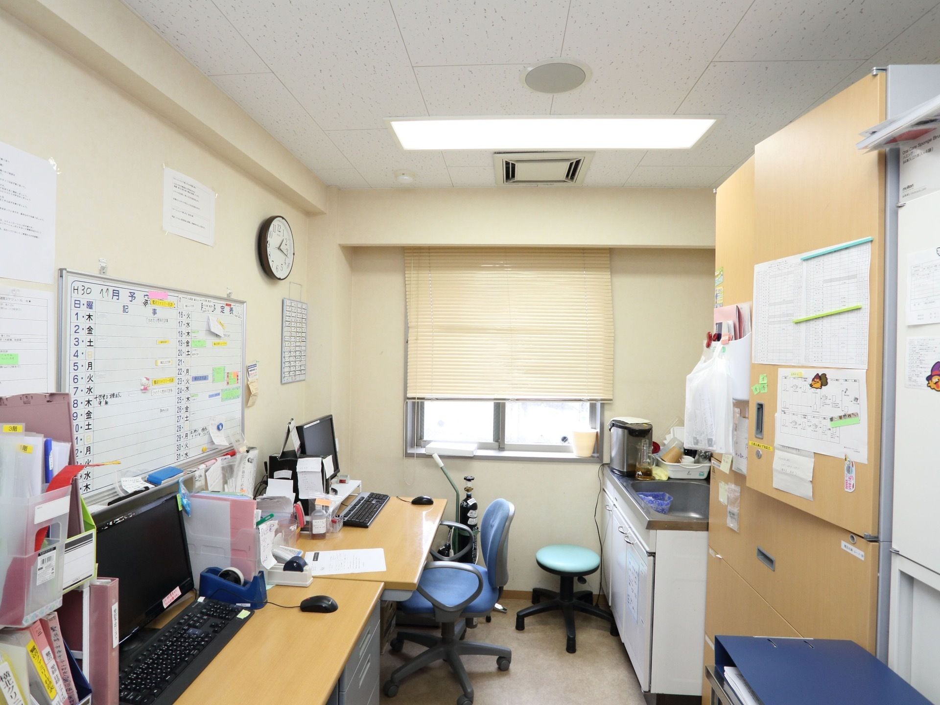 スタッフ室にはパソコンが置かれて、入居者様の健康管理など行っている。ホワイトボードには月のイベントを記載している。