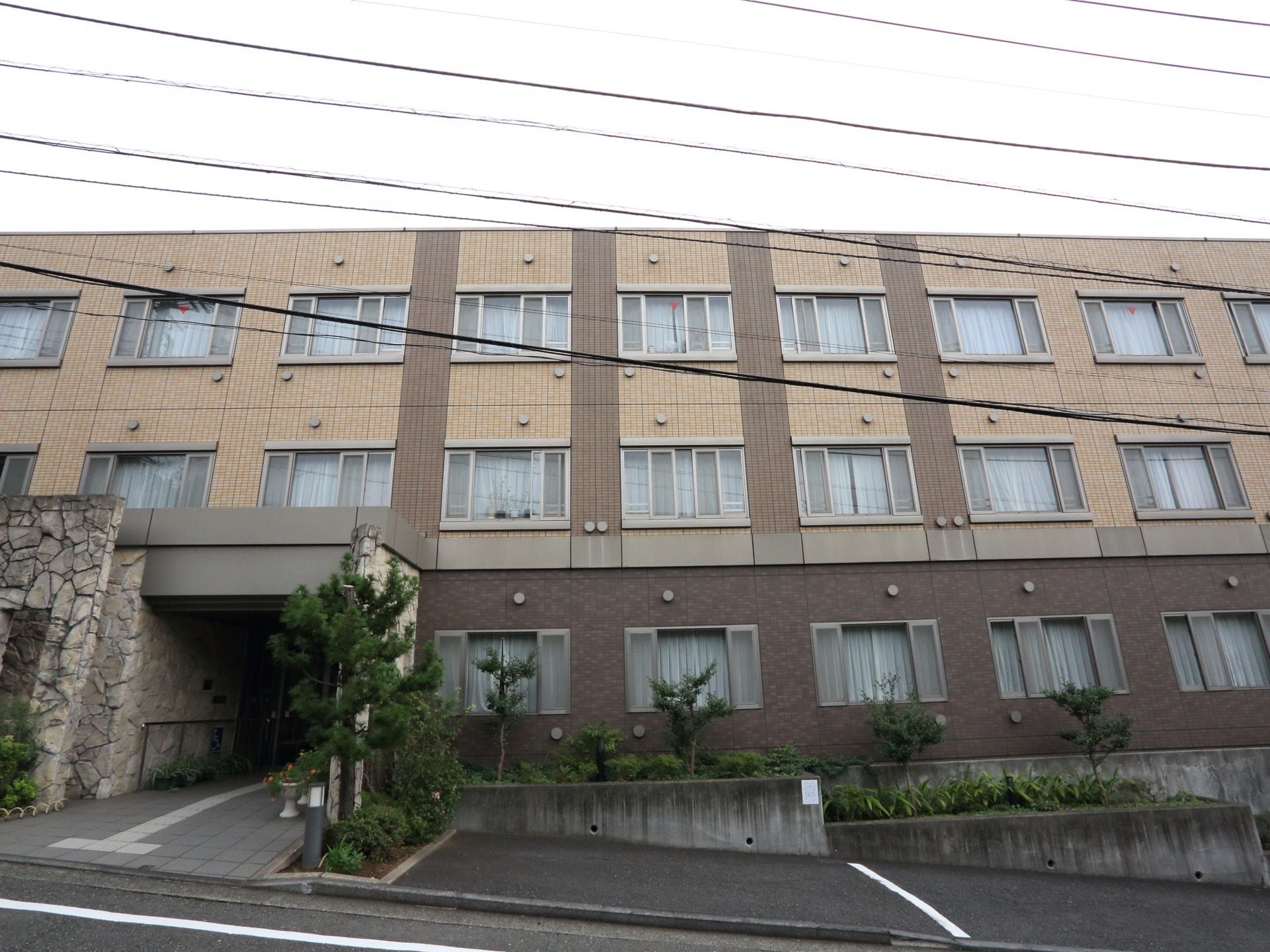 施設は3階建ての建物である。玄関まではスロープを設置している。建物の周囲には木や草花が植えられている。