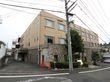 ブロックで囲まれた入り口部分が特徴的なマンション風な施設である。周囲は木が植えられて、穏やかな環境となっている。