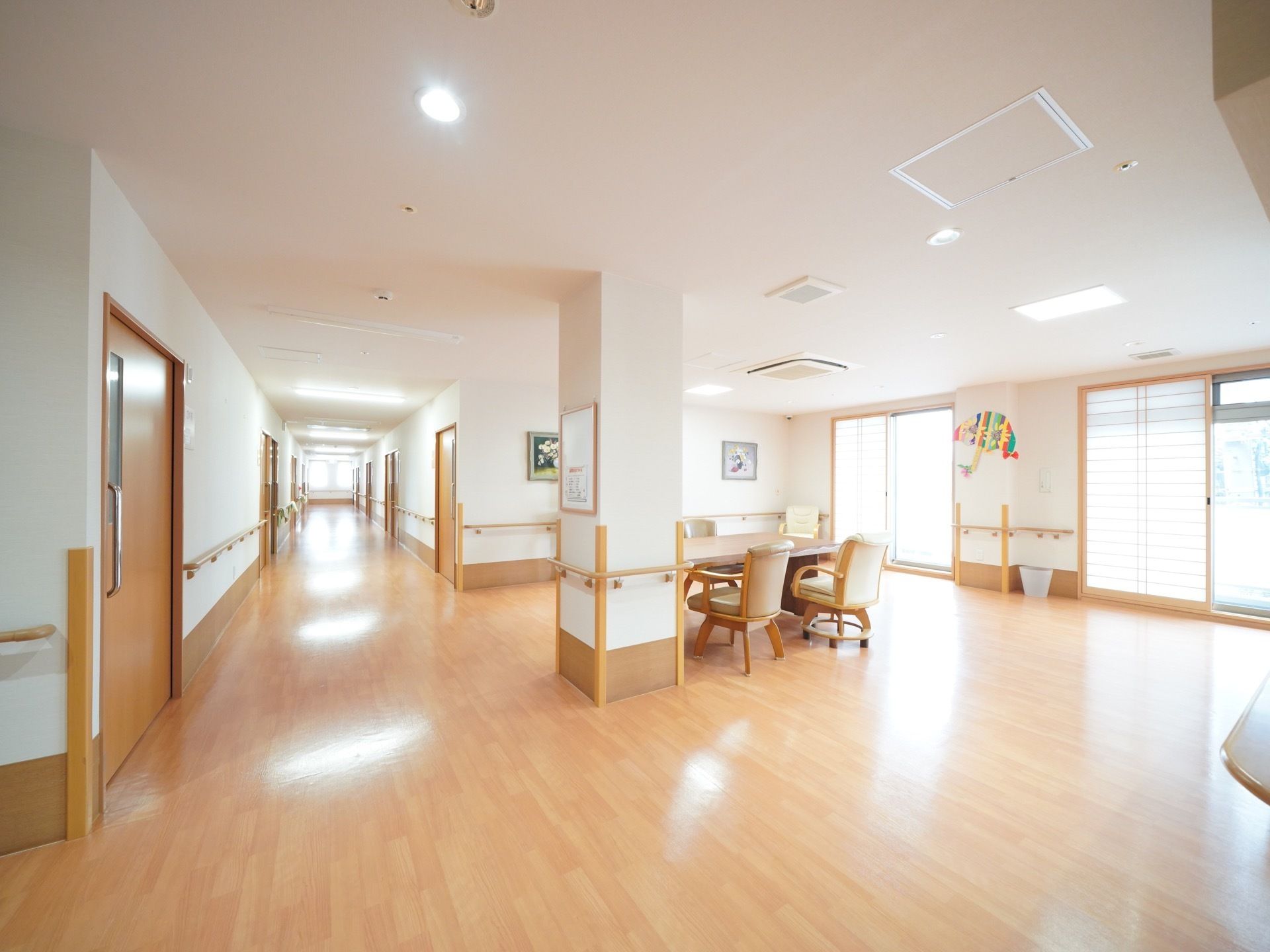 窓から明るい日差しが通路まで入り込んでいる。内障子が設置されたスペースが設置されており、広く開放的である。