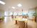 食堂は広く、奥は全面ガラス張りとなっている。中央には、ベージュ色のテーブルや白い椅子がたくさん並べられている。