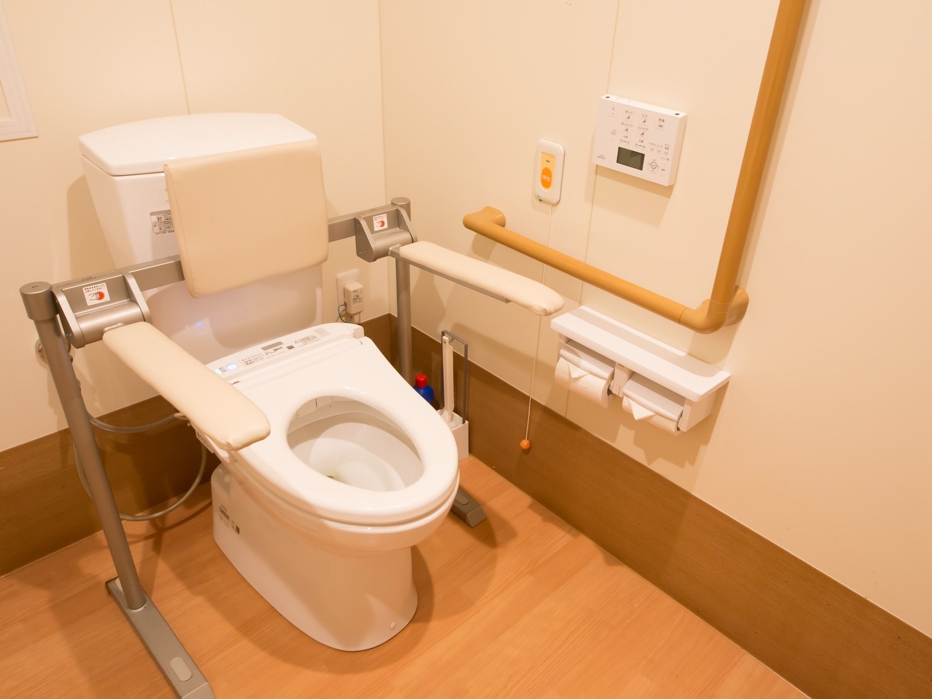 トイレの個室内には洋式の便器が備わり、その両側には可動式の手すりが設けられている。壁にはL字型の手すりが取りつけられている。