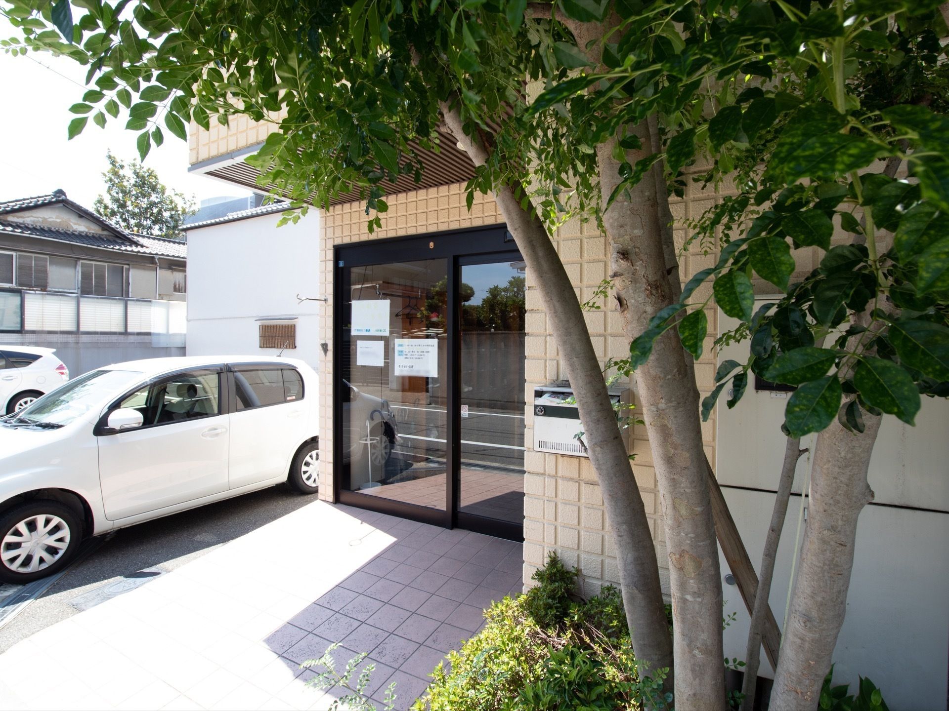 施設の外観。玄関前にグリーンが配置され、入り口そばに駐車場が設けられている。