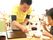 食事をしている女性の入居者様と食事のサポートを行う男性スタッフ。入居者様にあったサポートを行っている。